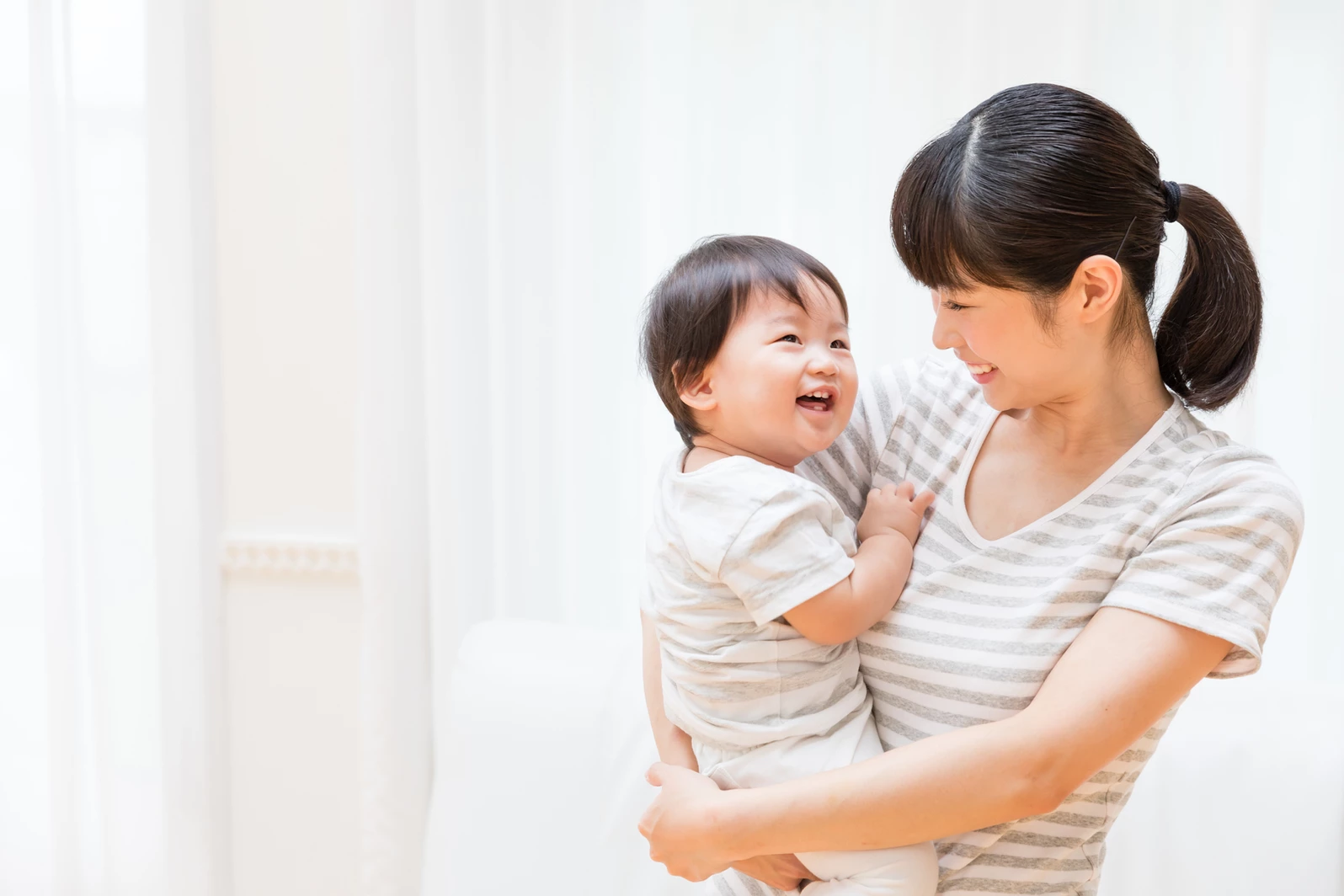 Asian mother holding child and smiling