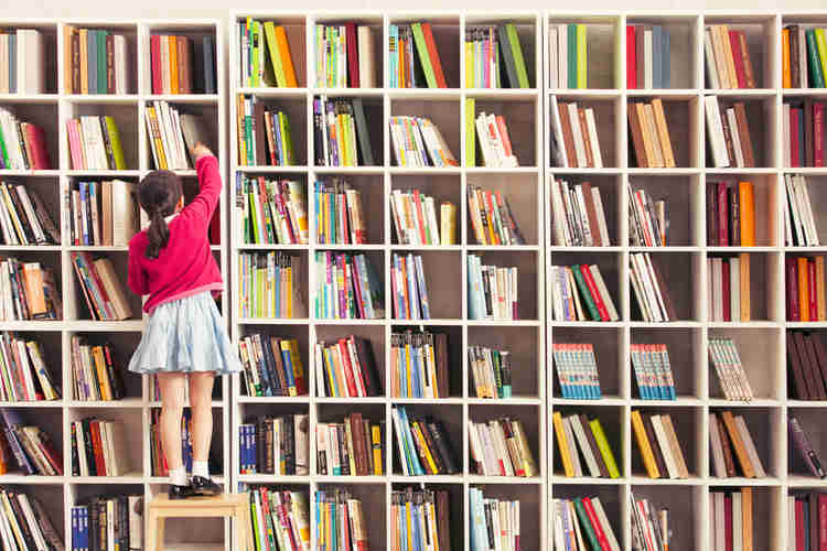 A child in front of a wall of books